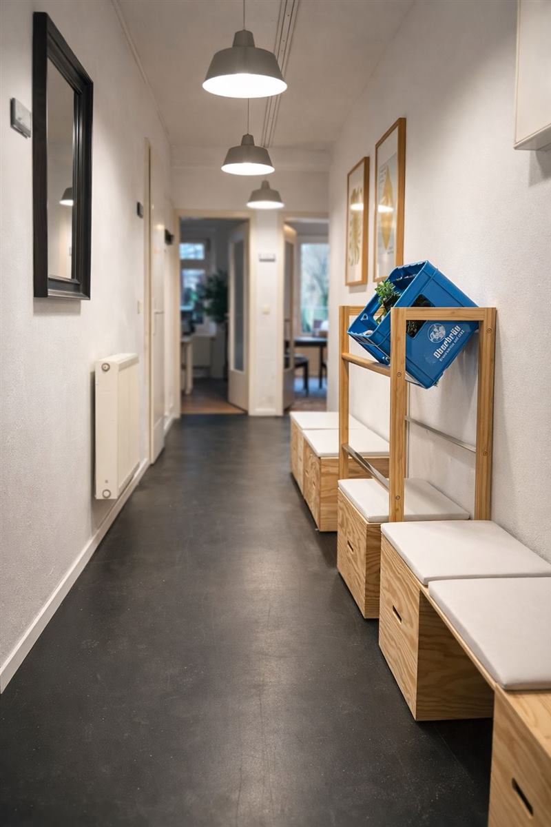 Langer Flur mit Hängelampen, Garderobe und Holzbänken